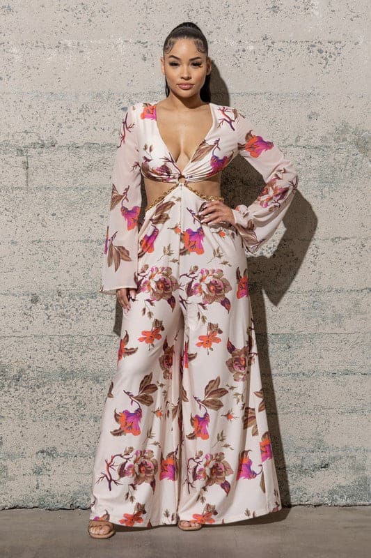 Avah Couture - This gorgeous floral jumpsuit features a fashionable v-shape neckline, open sides with chain detail, wide pants, and a beautiful floral print. This piece is one to own. Imagine how you look and feel as it flows in the warm summer breeze on your next vacation!   All-over floral print V-neckline Long bell sleeves Open sides with chain detail Open back Wide leg Hand wash cold. Line dry.  